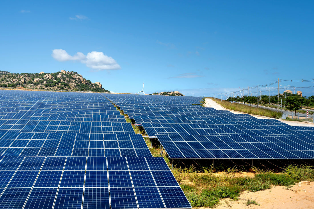 A field of modern solar panels under a bright blue sky, representing the clean energy revolution.