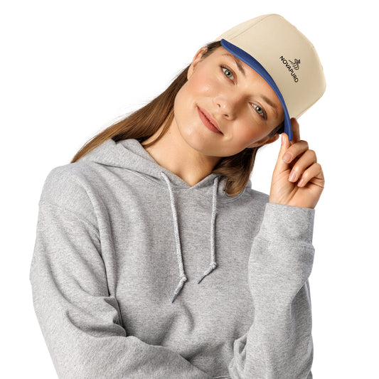 A woman wearing the minimalist Novapuro 5-panel cap in light beige with a blue visor, showcasing clean Scandinavian design.