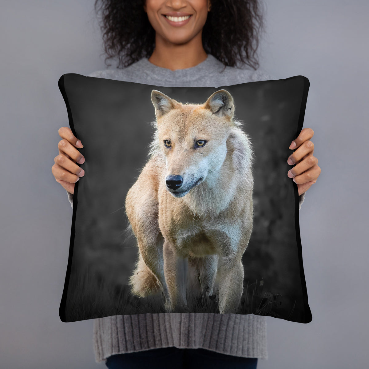Novapuro x Auli Leivonen dark decorative throw pillow featuring a majestic Nordic wolf design, resting on a bed with dark blue bedding.