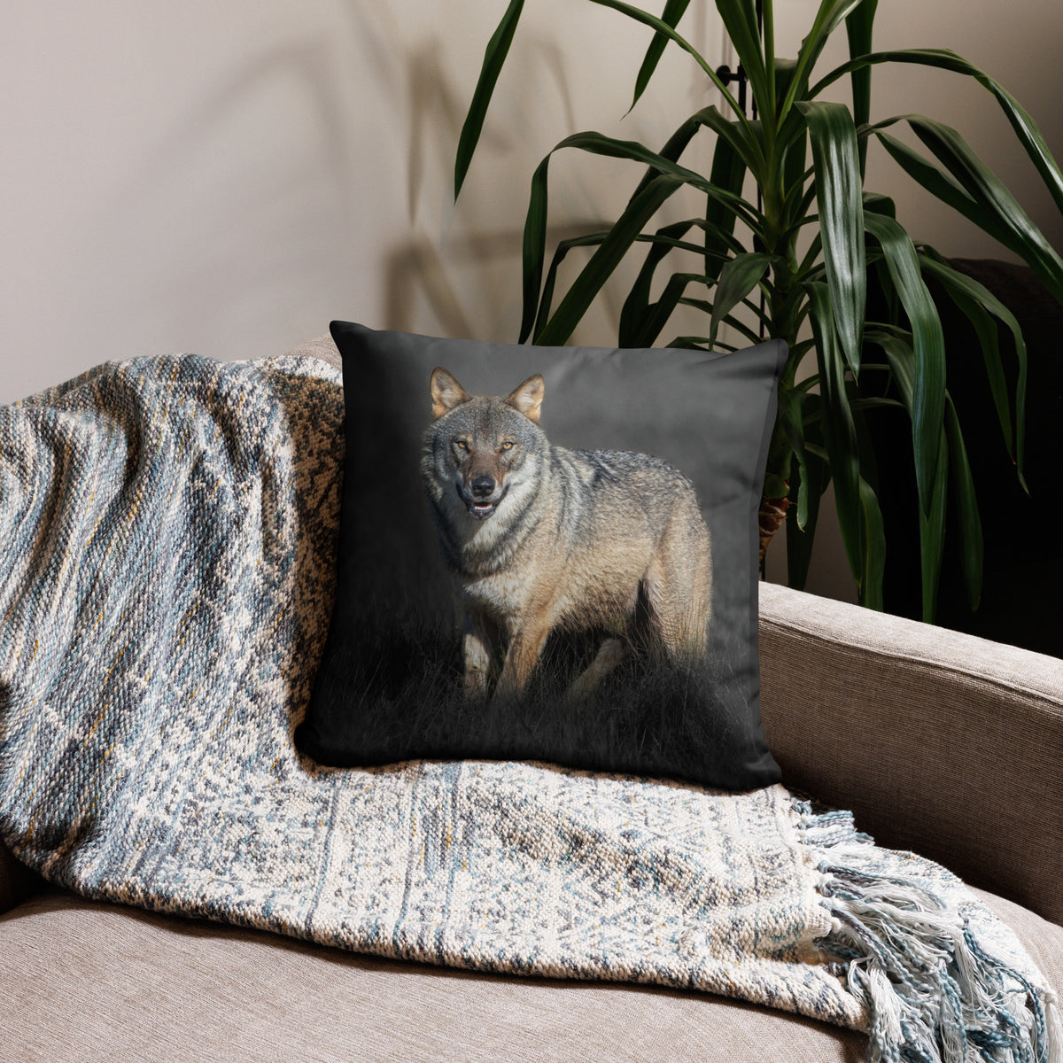 Elegant premium throw pillow featuring the 'Dark Alpha Wolf' photograph by Auli Leivonen, styled in a cozy living room setting. Scandinavian nature-inspired home decor.   