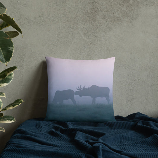 A stylish premium throw pillow featuring an original photograph of two moose in the mist by Mikko Monto, placed in a cozy home setting.