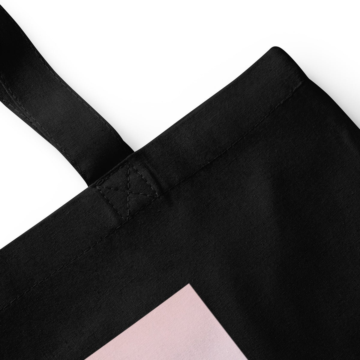 Close-up view of the black durable cotton tote bag showcasing the medium-length carrying handles and spacious design