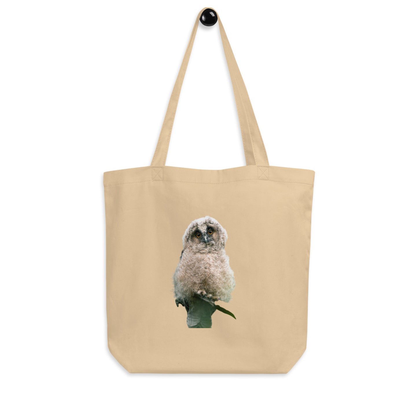 Front view of a sand-colored organic cotton tote bag featuring stippling art of a Long-eared Owl by Mikko Monto.