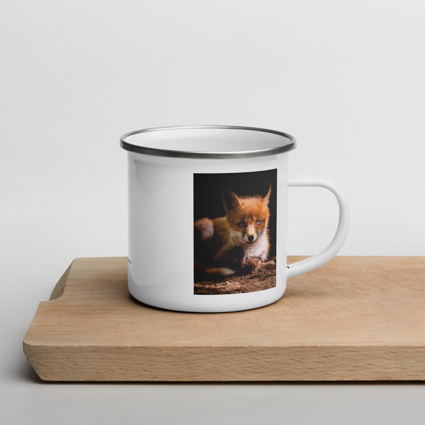 Niko Laurila x Novapuro white enamel camper mug featuring an original red fox wildlife photograph resting on a wooden board