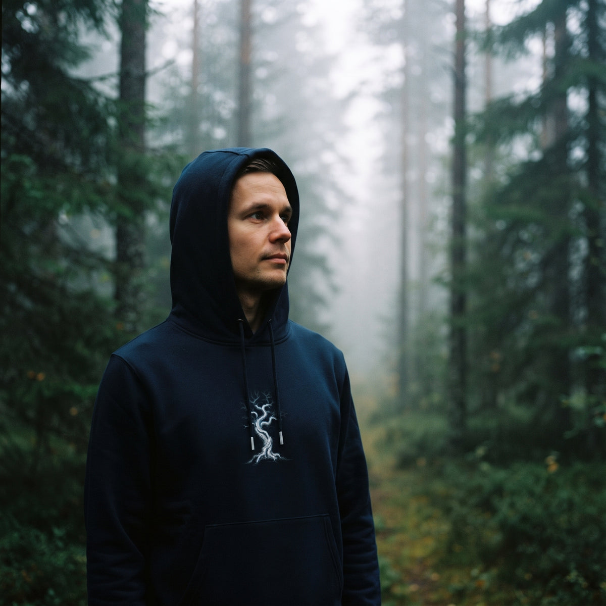 Novapuro "Kelo" Heavyweight Organic Cotton Hoodie in French Navy worn by a man in a misty Nordic pine forest, showcasing sustainable and organic minimalist outdoor apparel.