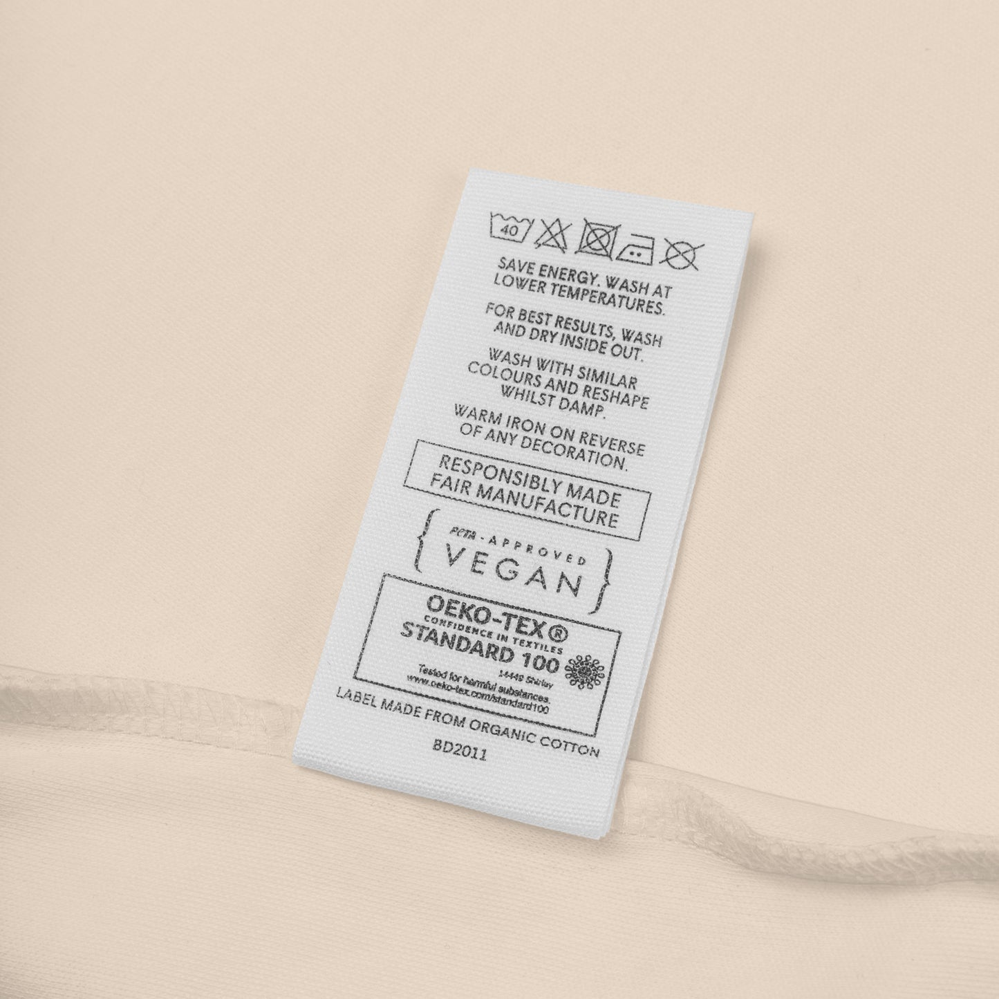 Close-up of the certified organic cotton fabric and care label on the eco-friendly Novapuro baby bodysuit