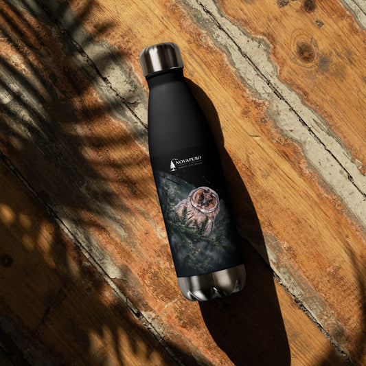 A black double-walled stainless steel water bottle featuring a Nordic long-eared owl chick print by Jarno Virtanen, resting on a wooden surface.