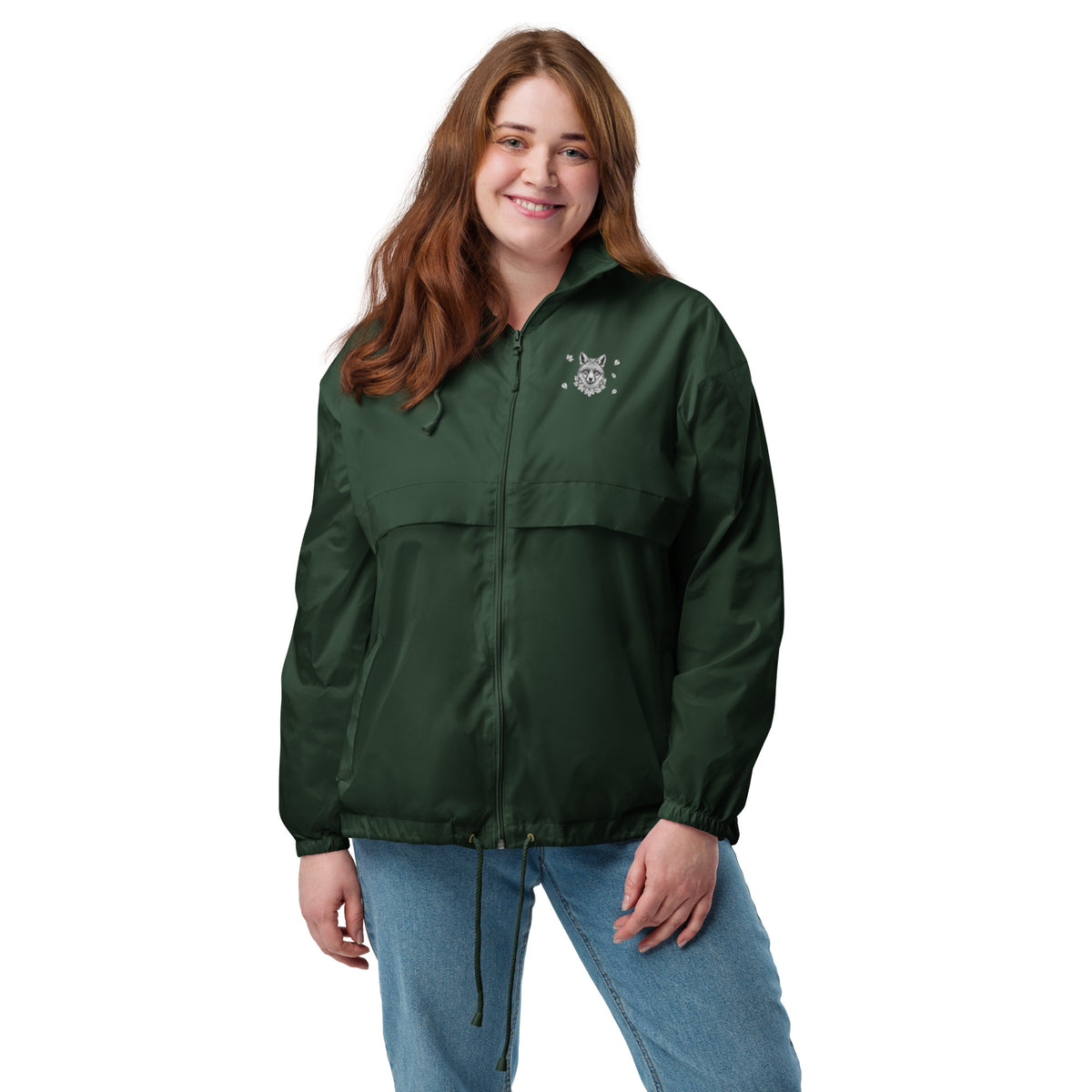 A smiling woman wearing the dark green Novapuro x Annette Thomé-Marttinen 'Nordic Fox' windbreaker jacket, featuring a minimalist white fox illustration on the chest.