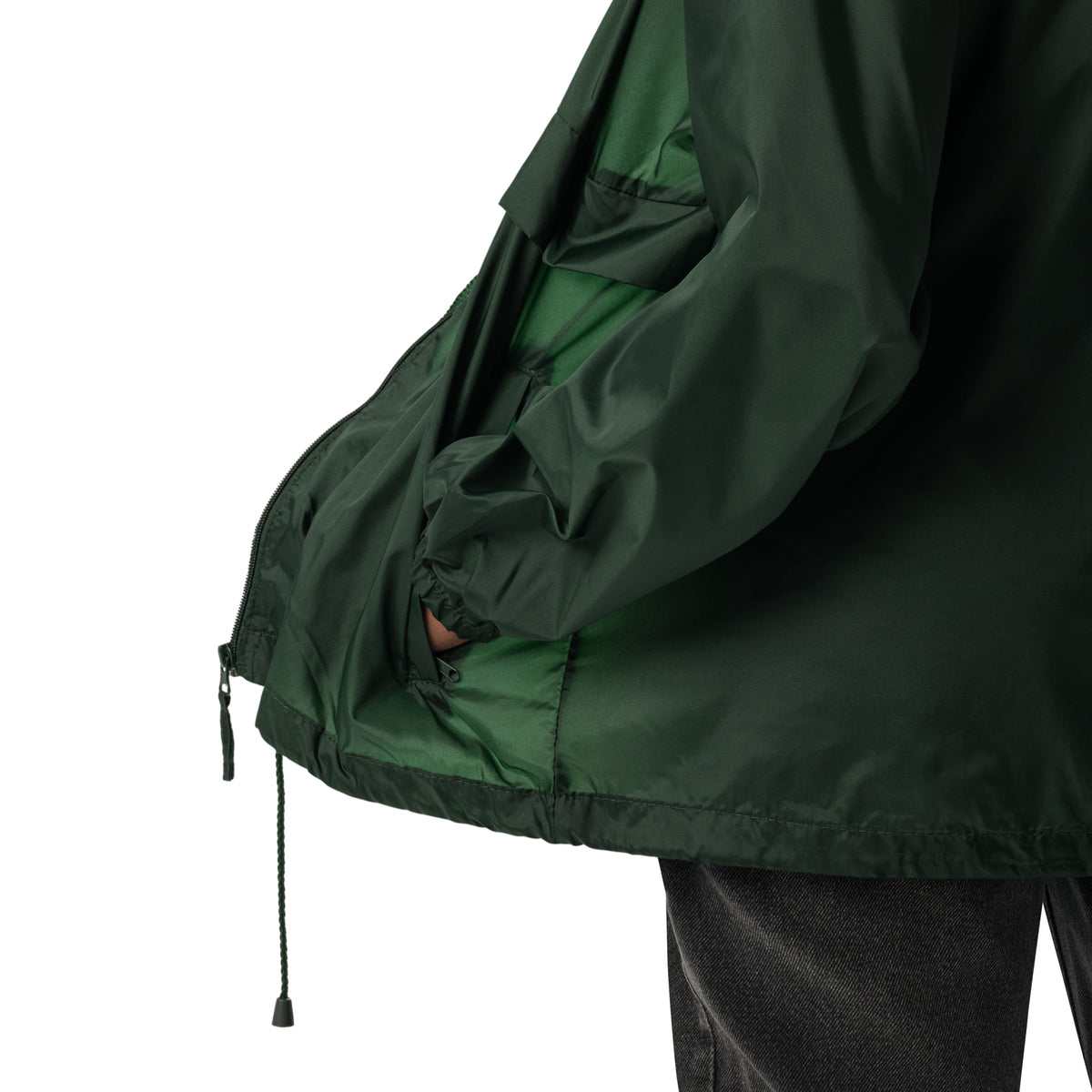 A smiling woman wearing the dark green Novapuro x Annette Thomé-Marttinen 'Nordic Fox' windbreaker jacket, featuring a minimalist white fox illustration on the chest.