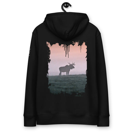 A person wearing a black heavyweight organic cotton hoodie seen from the back, featuring a distressed splash-edge print of a majestic bull moose by Mikko Monto.