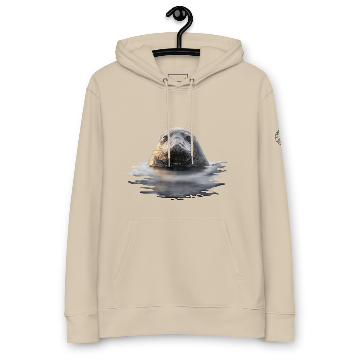 Front view of a sand-colored eco-friendly heavyweight sweater on a hanger, showcasing Jetro Luhtaa's Nordic wildlife photography of a seal emerging from calm waters.
