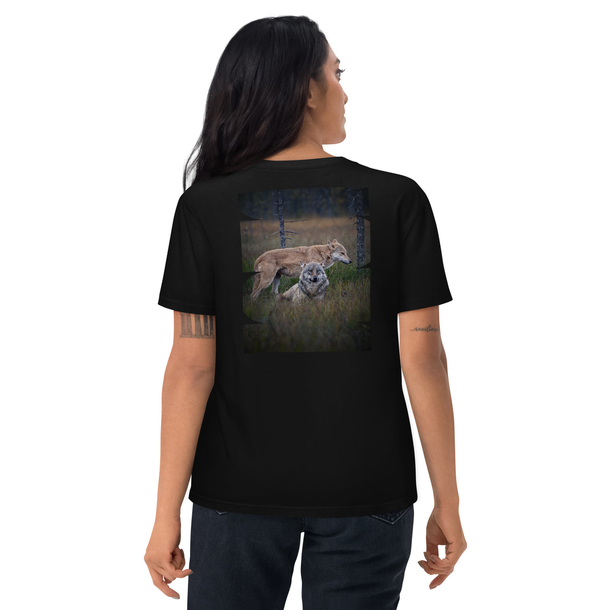 Female model wearing a black unisex organic cotton t-shirt with the 'Leaders of the Pack' alpha wolf couple back print. Eco-conscious Scandinavian nature apparel.   
