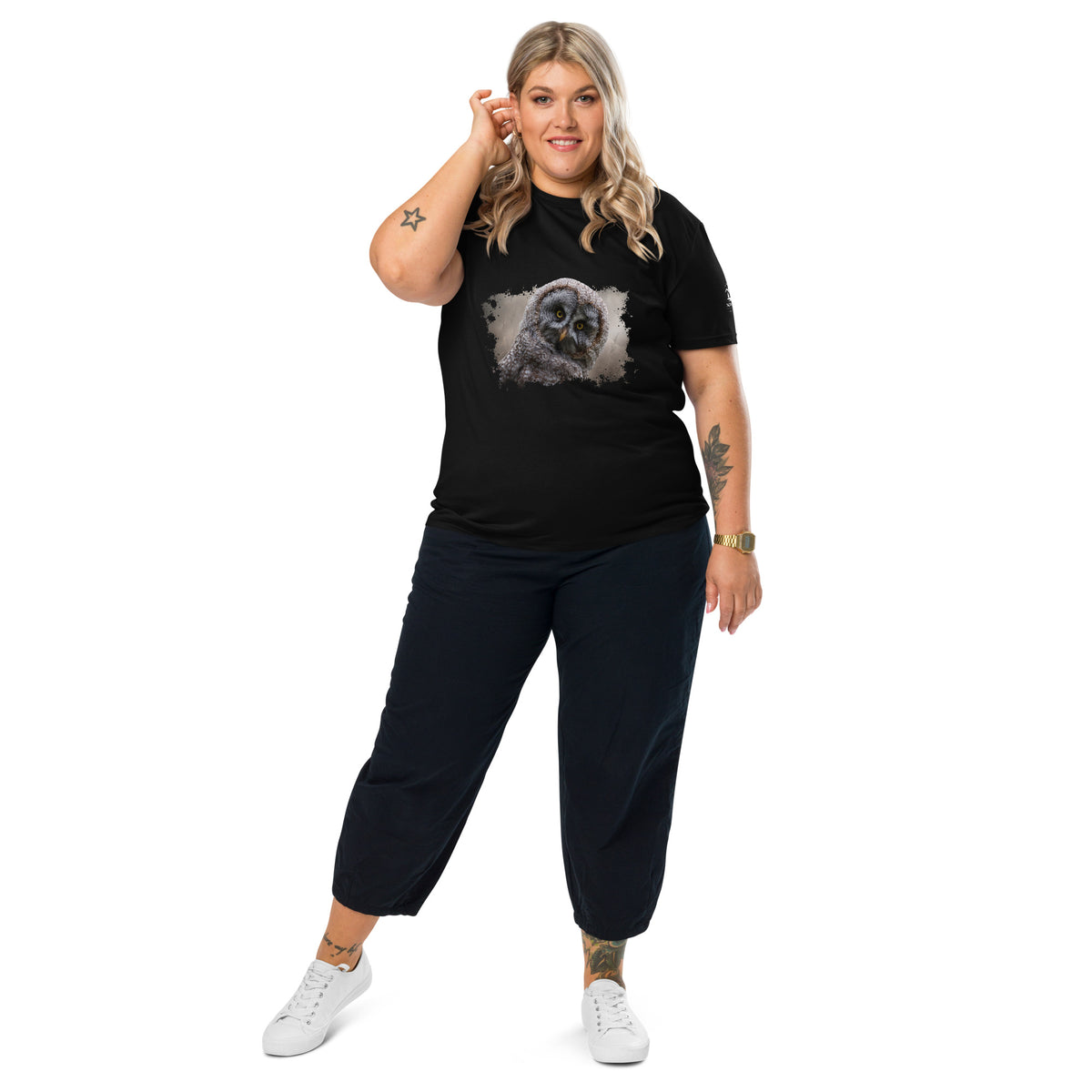 Woman wearing a black Novapuro organic eco t-shirt with a subtle chest emblem. Part of the Jarno Virtanen Great Grey Owl collection. Sustainable Nordic streetwear.