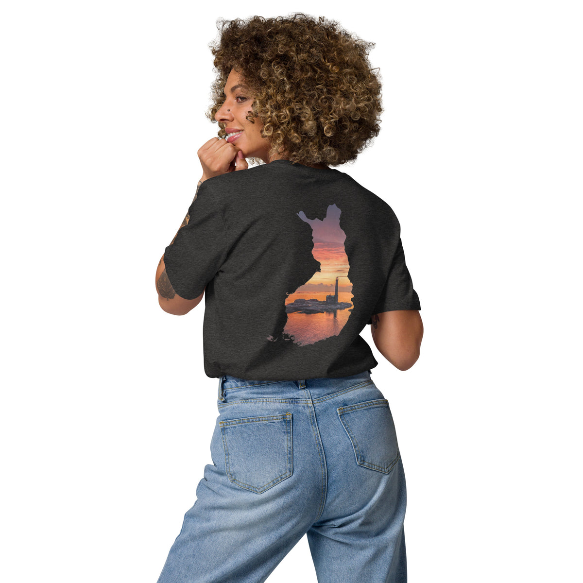 A woman wearing the black Niko Laurila x Novapuro organic cotton t-shirt, showcasing the back print of a lighthouse photograph masked inside a silhouette of Finland.   