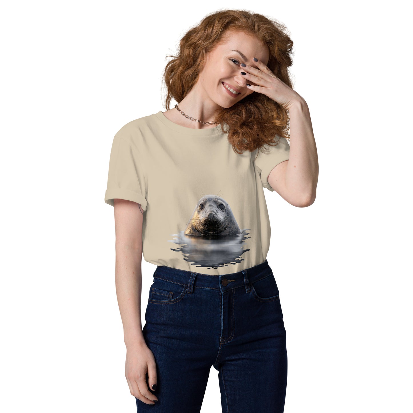 A female model wearing a sand-colored sustainable organic cotton t-shirt featuring a Saimaa ringed seal graphic, offering premium eco-friendly streetwear for nature lovers.