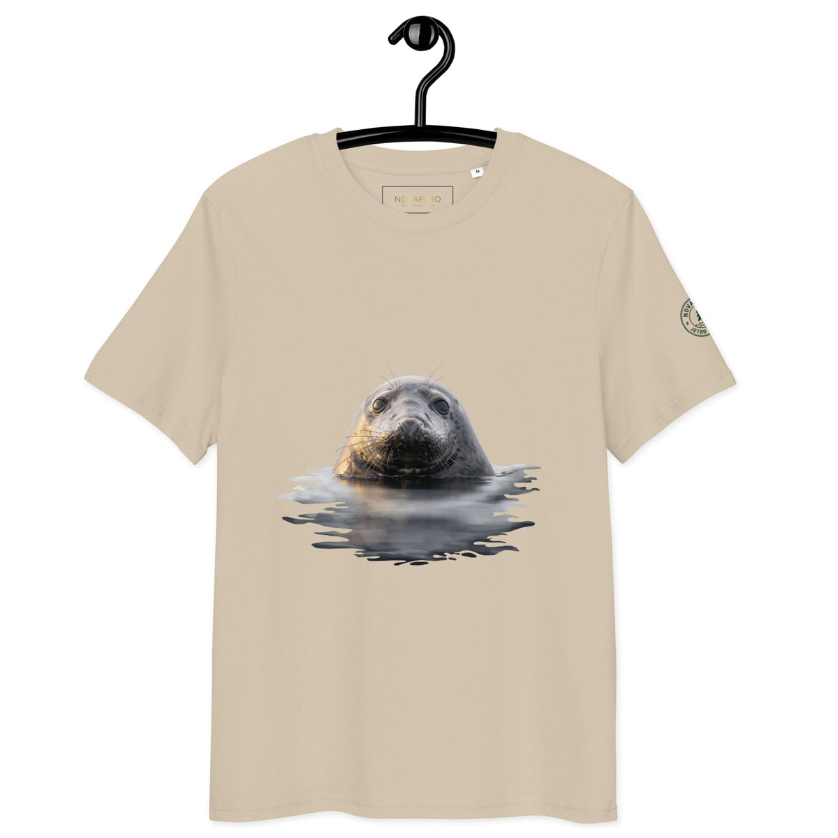 Front view of a sand-colored premium organic cotton t-shirt on a hanger, showcasing Jetro Luhtaa's Nordic wildlife photography of a Saimaa ringed seal.