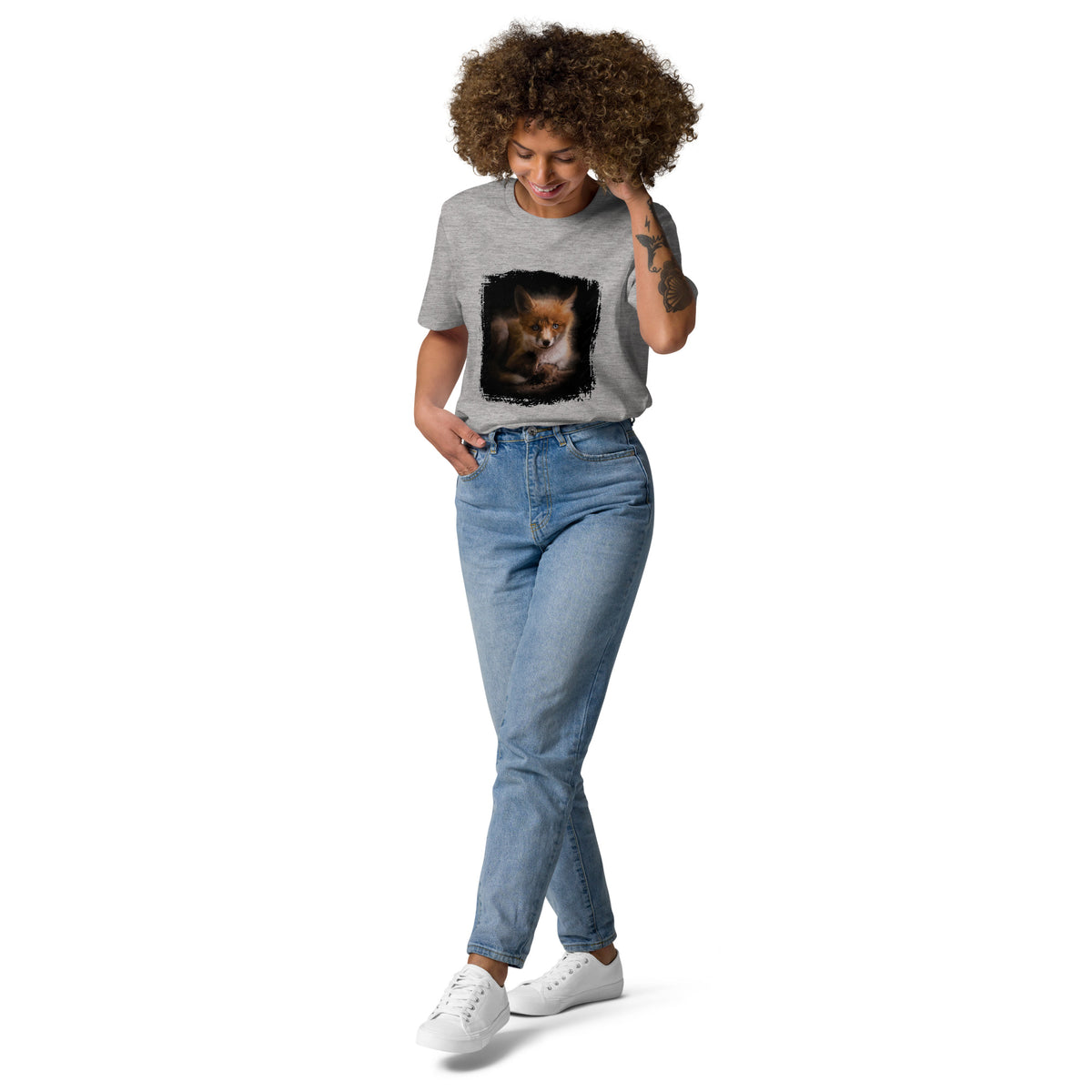A person wearing a sustainable black organic cotton t-shirt featuring a wild fox nature photograph by Niko Laurila.