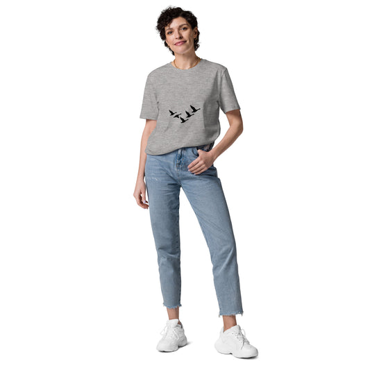 Model wearing "The Return" organic cotton t-shirt with minimalist migratory bird flock design by Novapuro