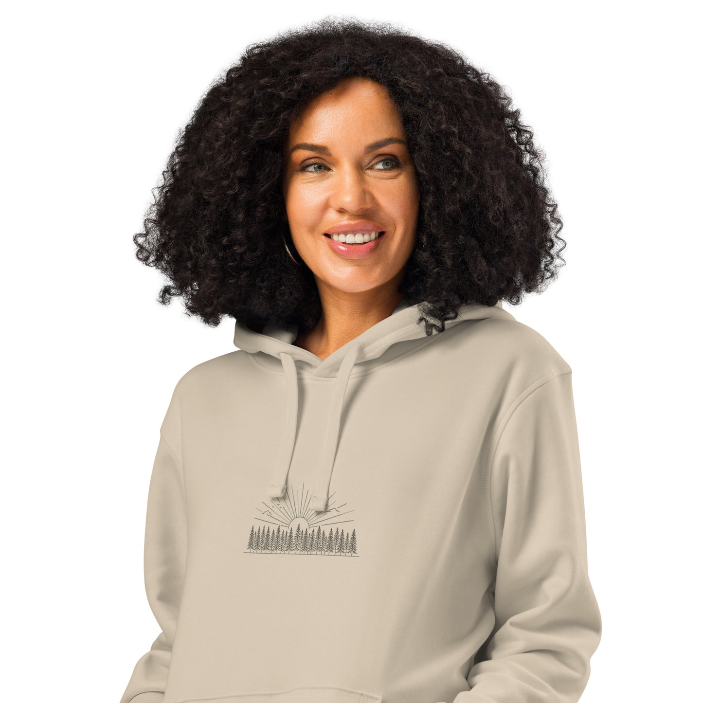Model wearing a natural beige organic cotton hoodie featuring a minimalist Nordic forest and sunrise graphic by Novapuro