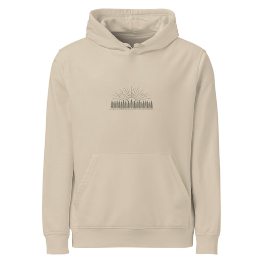 Model wearing a natural beige organic cotton hoodie featuring a minimalist Nordic forest and sunrise graphic by Novapuro