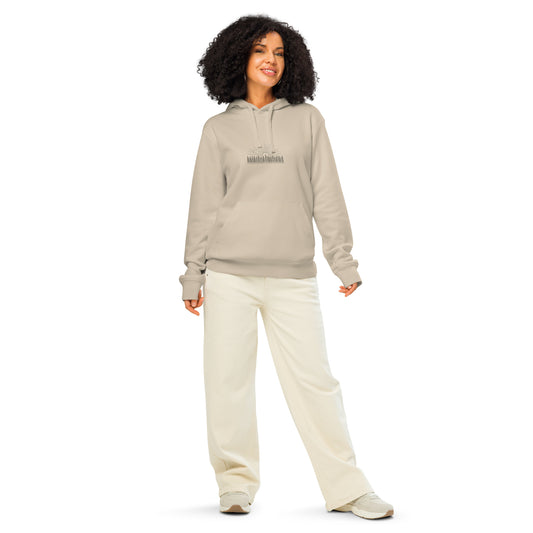 Model wearing a natural beige organic cotton hoodie featuring a minimalist Nordic forest and sunrise graphic by Novapuro