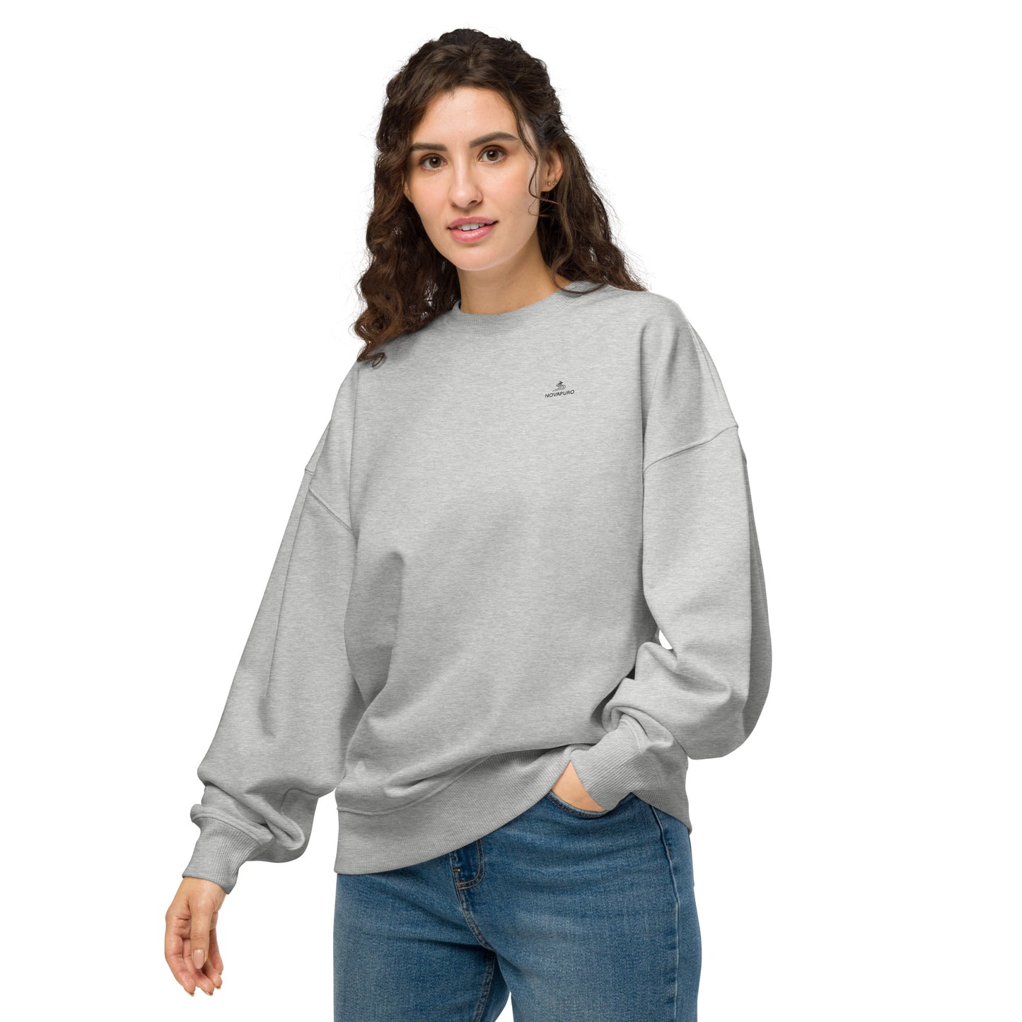 Front view of a woman wearing the grey eco-friendly oversized sweater featuring the minimalist Novapuro logo.