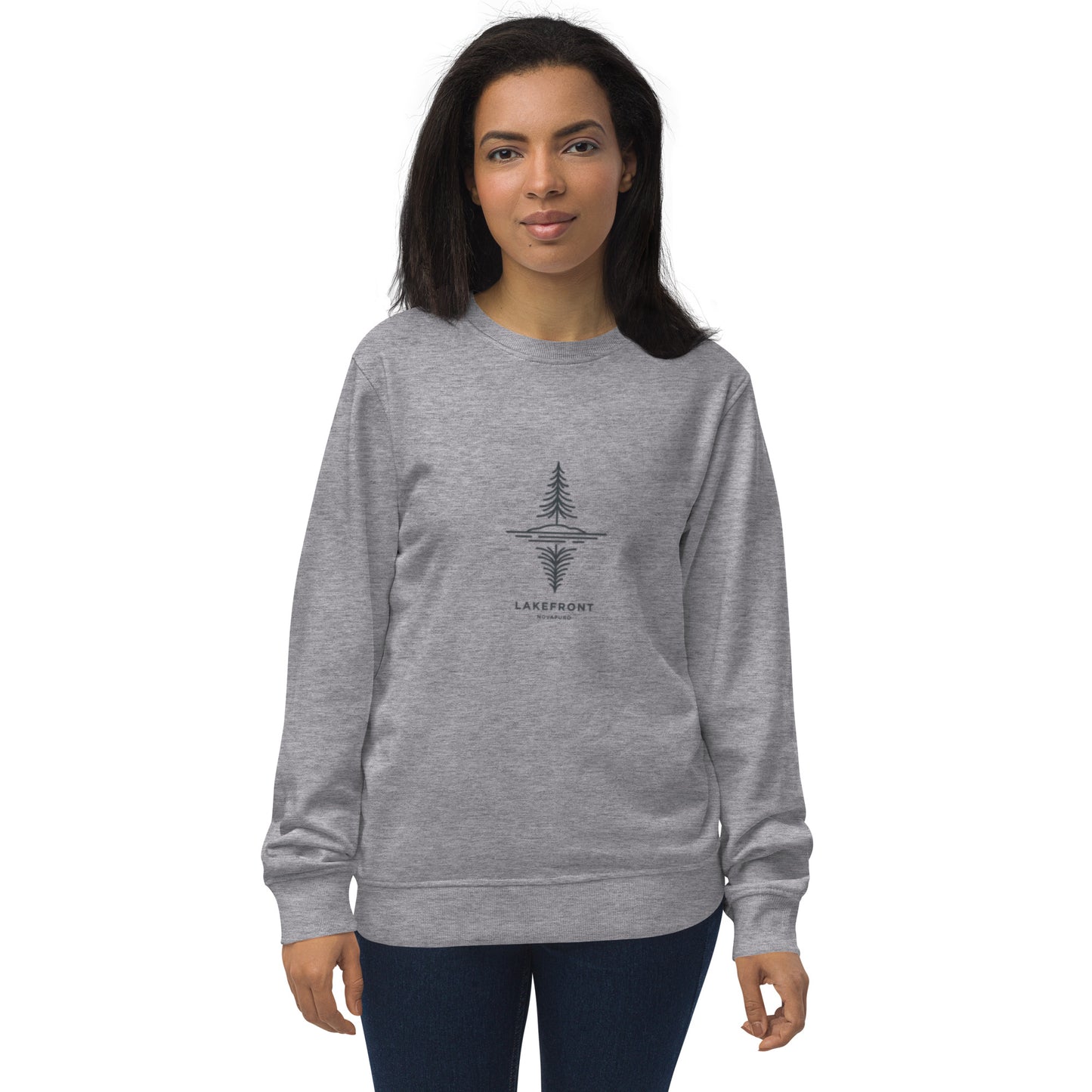A model wearing a white premium organic sweatshirt featuring a minimalist line art illustration of a pine tree reflecting on a Nordic lake.