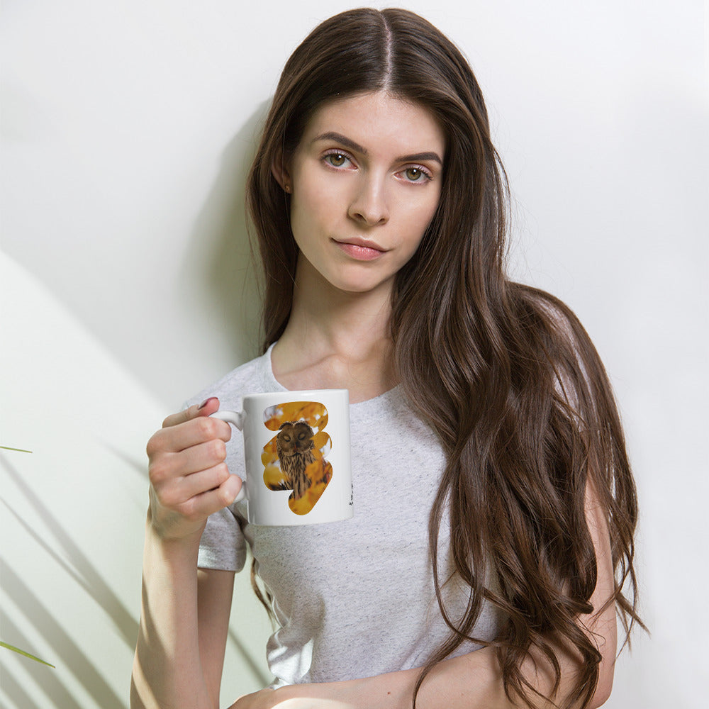 Premium white glossy ceramic coffee mug featuring a fine art nature photograph of a Nordic Ural owl from the Tarja x Novapuro collection.
Woman holding a white ceramic mug featuring a Nordic Ural owl nature photograph from the Tarja x Novapuro collection.