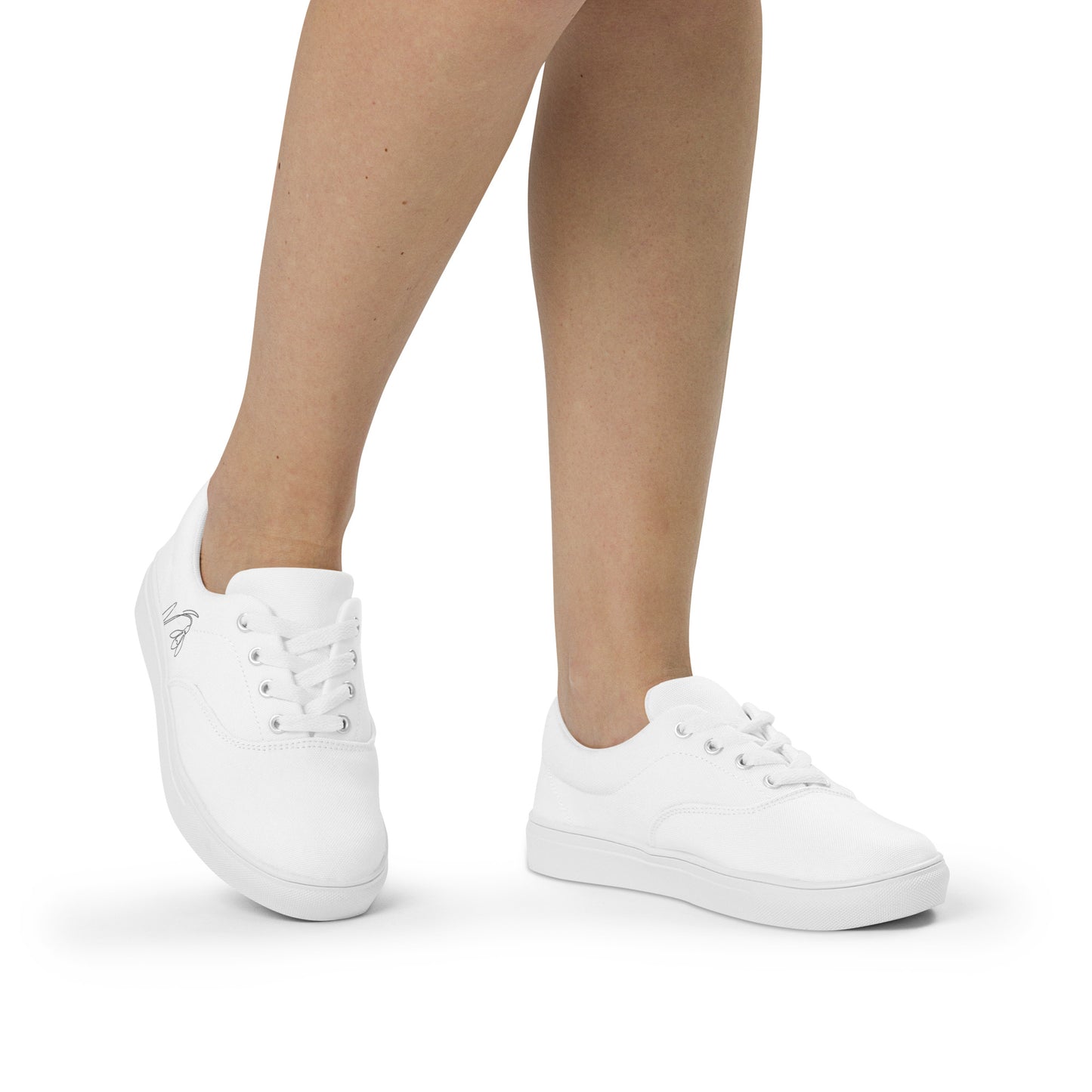Minimalist white women's canvas sneakers with black First Bloom snowdrop design by Novapuro
