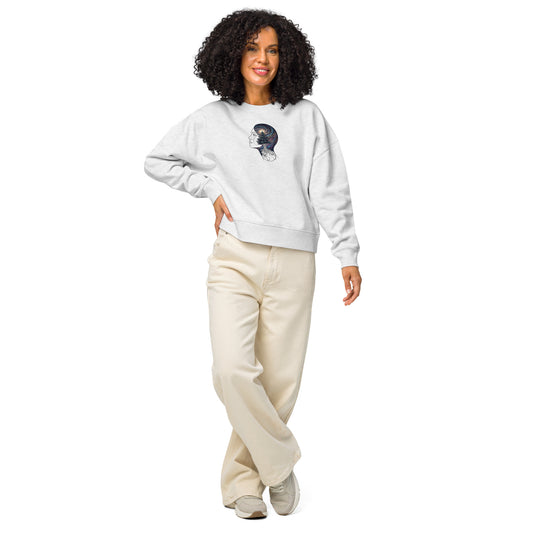 A woman smiling and wearing a white organic cotton crew neck sweatshirt featuring a cosmic forest silhouette design, paired with light trousers.
