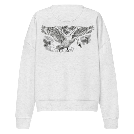 Woman wearing a white organic sweatshirt with a large, intricate illustration of a flying swan on the back. Premium sustainable Nordic fashion.